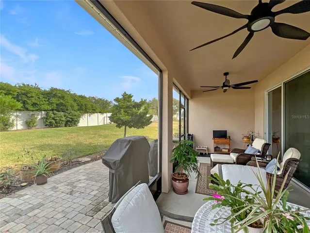 a view of a patio with couches chairs potted plants and a big yard