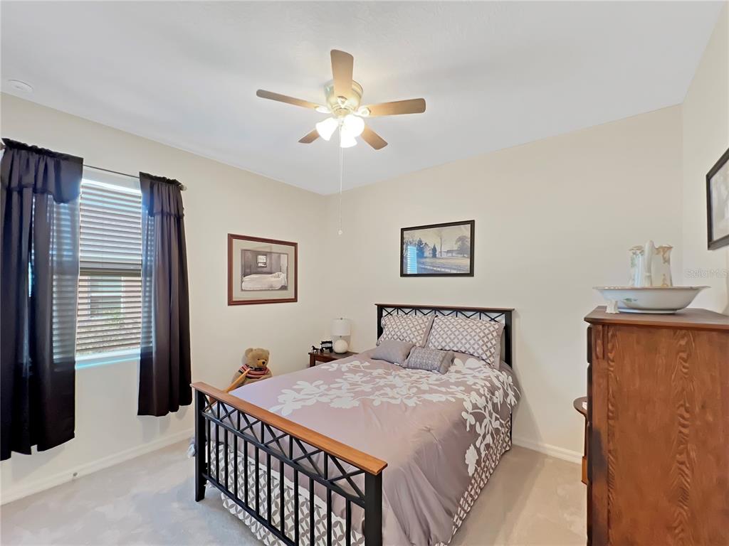 6265 Southwest 88th Loop Ocala, FL 34476 - Photo 8 of 42 a bedroom with a large bed and a chandelier