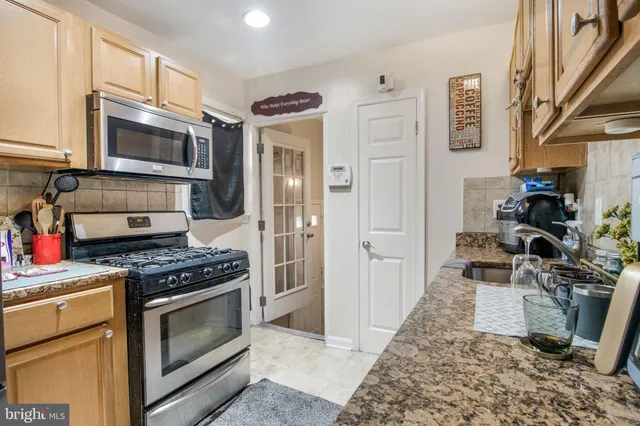 a kitchen with stainless steel appliances granite countertop a stove a microwave and a refrigerator
