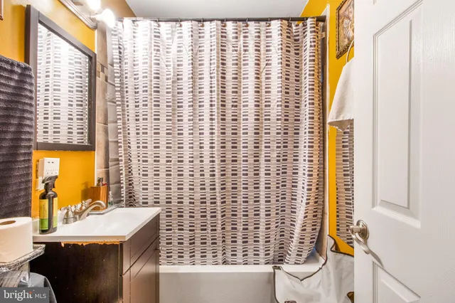 a bathroom with a sink a toilet and shower curtain