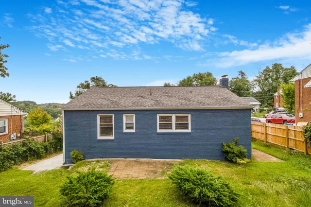 a backyard of a house with potted plants and large tree