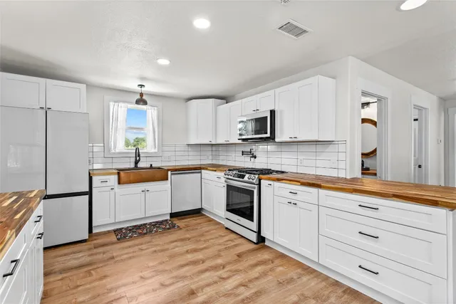 a kitchen with granite countertop white cabinets and white appliances