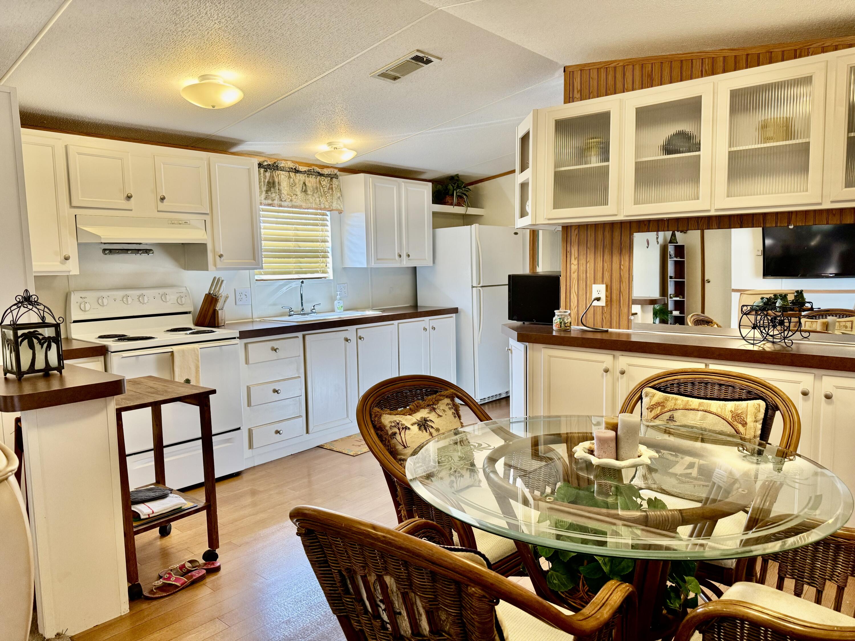 2305 Southeast 31st Street Okeechobee, FL 34974 - Photo 7 of 30 a kitchen with stainless steel appliances kitchen island granite countertop a stove a sink and a microwave