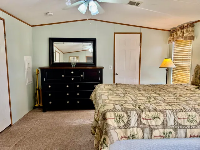 a bedroom with a bed and a mirror on dresser