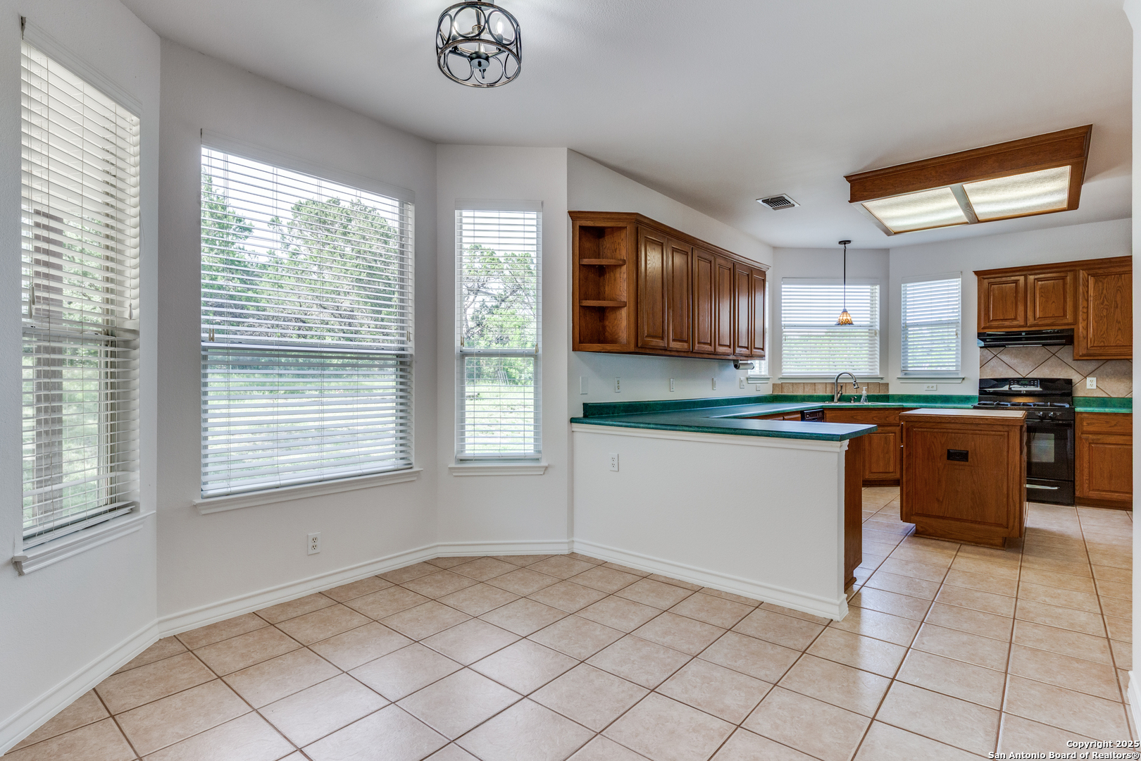 9109 Windwick Boerne, TX 78006 - Photo 13 of 35 a kitchen with stainless steel appliances granite countertop a stove a sink and a microwave