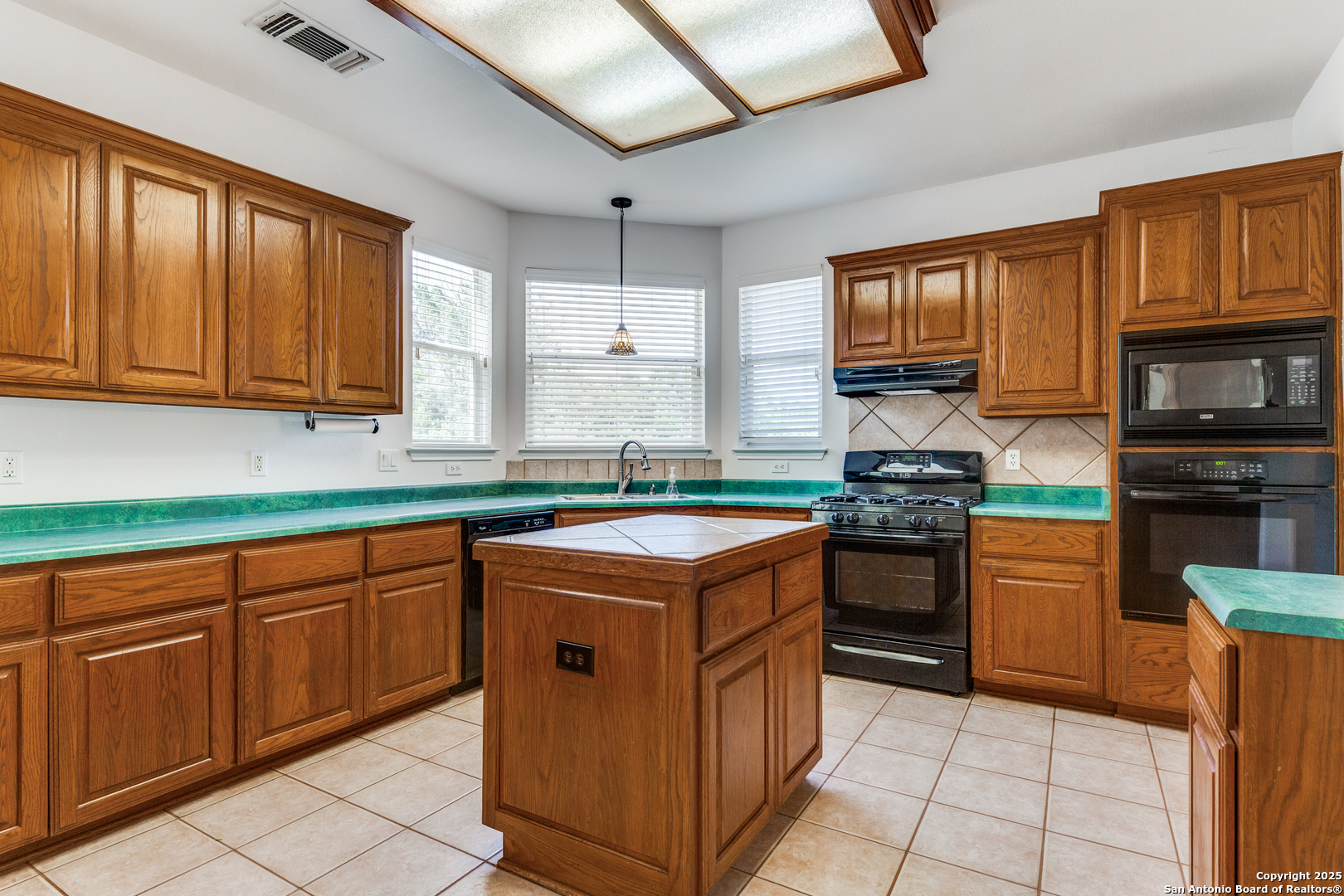 9109 Windwick Boerne, TX 78006 - Photo 14 of 35 a kitchen with stainless steel appliances granite countertop a stove top oven a sink dishwasher and a microwave oven on the blue kitchen countertops