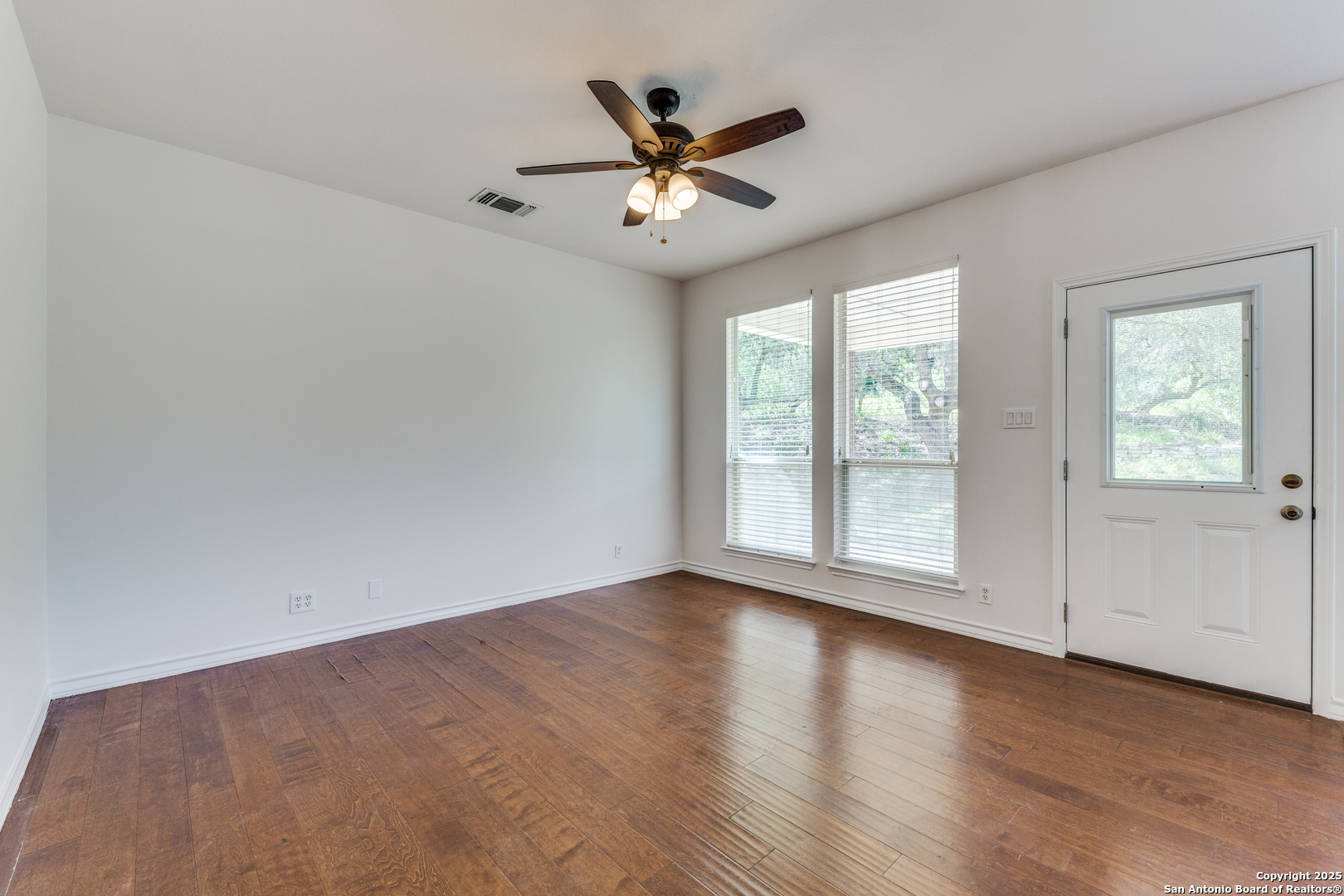 9109 Windwick Boerne, TX 78006 - Photo 17 of 35 an empty room with wooden floor and windows