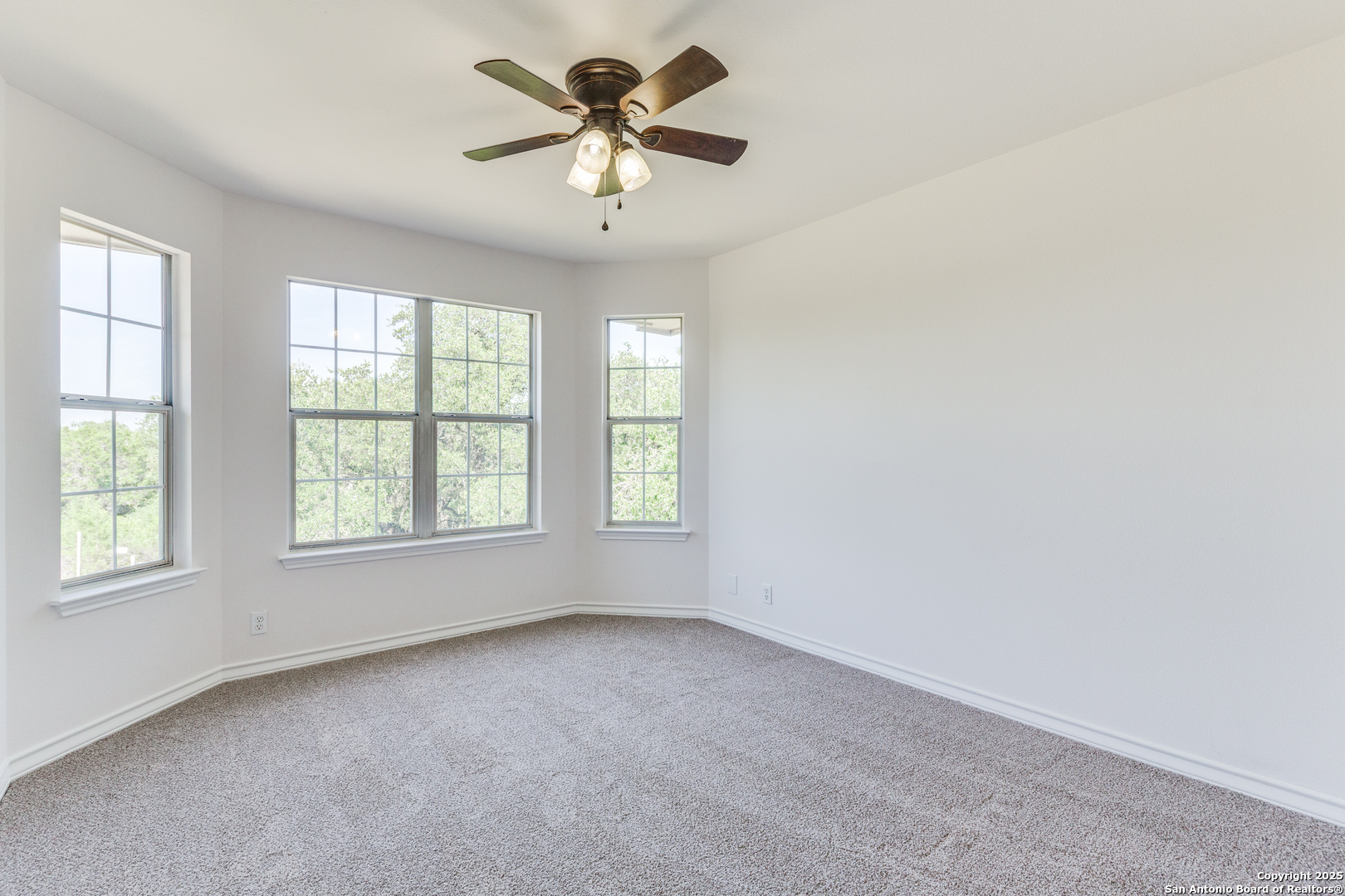 9109 Windwick Boerne, TX 78006 - Photo 21 of 35 an empty room with windows and chandelier fan