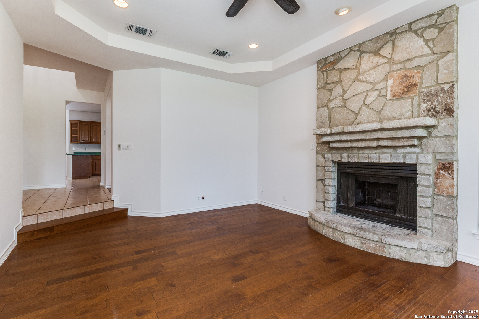 9109 Windwick Boerne, TX 78006 - Photo 9 of 35 an empty room with wooden floor a fireplace and windows