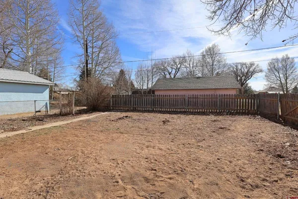 a view of backyard with white fence