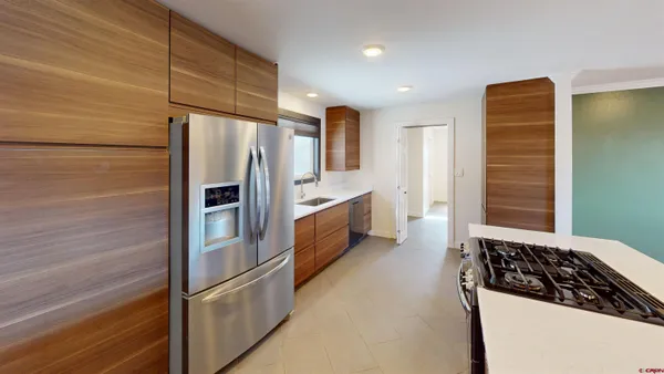 a kitchen with stainless steel appliances granite countertop a refrigerator and a stove