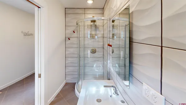 a bathroom with a glass shower door and a glass door shower