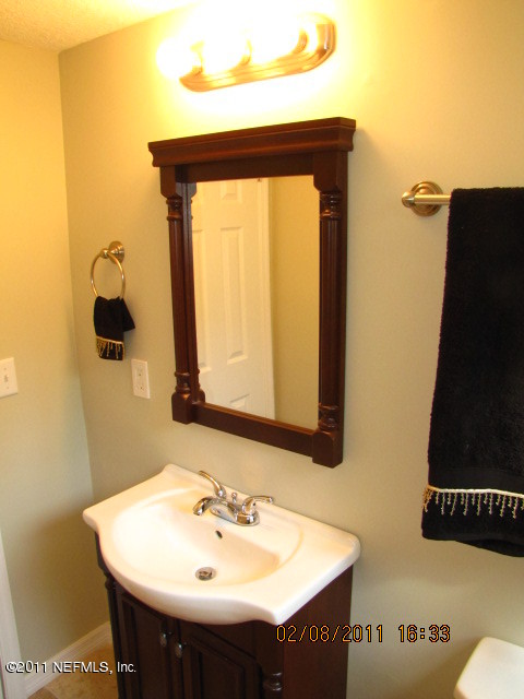 10459 Rutgers Road Jacksonville, FL 32218 - Photo 13 of 28 a bathroom with a sink and a mirror