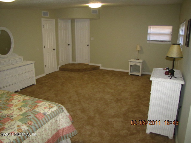 10459 Rutgers Road Jacksonville, FL 32218 - Photo 18 of 28 a bedroom with a bed and a mirror