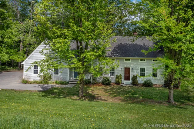 a front view of a house with a yard and trees