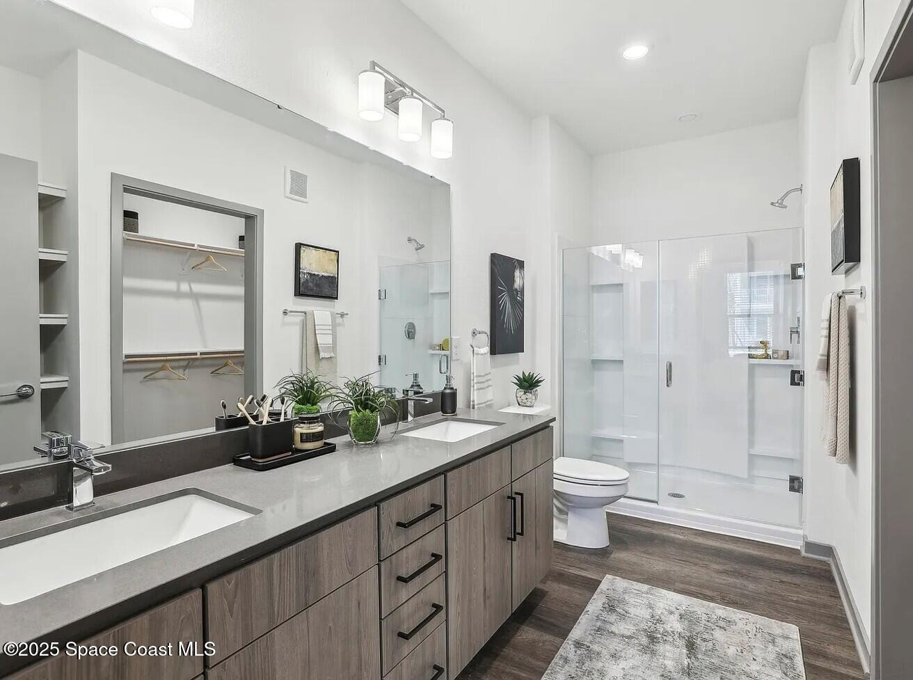 1073 Journey Circle, Unit 107 Rockledge, FL 32955 - Photo 8 of 10 a spacious bathroom with a double vanity sink toilet mirror and bathtub