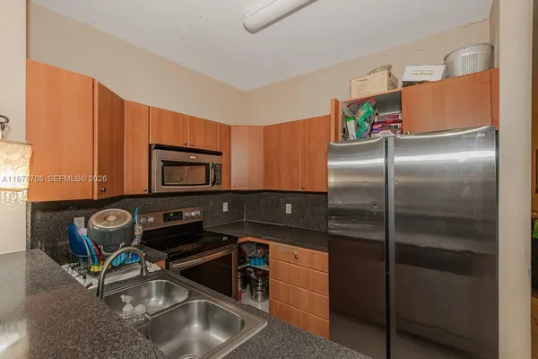 a kitchen with a refrigerator sink and cabinets