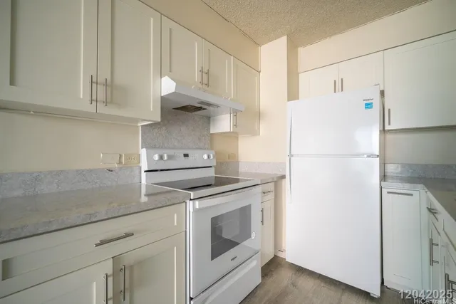 a kitchen with stainless steel appliances white cabinets and a refrigerator