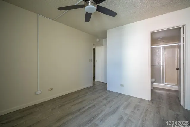 an empty room with wooden floor a ceiling fan and closet