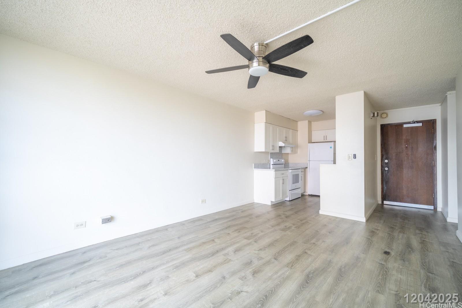 3161 Ala Ilima Street, Unit 1403 Honolulu, HI 96818 - Photo 8 of 24 a view of a livingroom with wooden floor and white walls