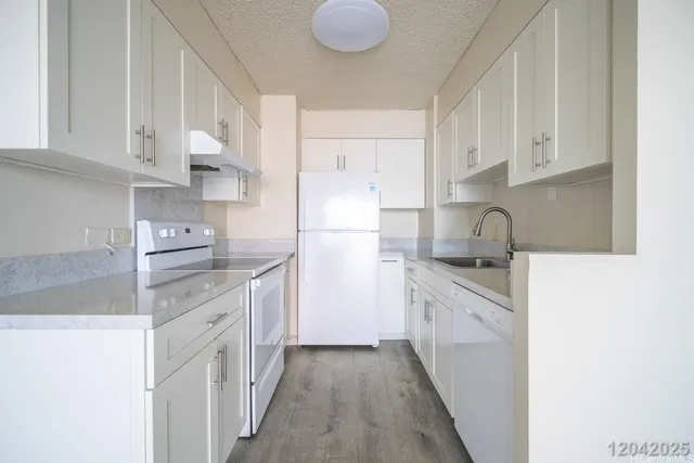 a kitchen with granite countertop a sink stove and refrigerator