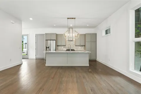 a large kitchen with stainless steel appliances granite countertop a large counter top and wooden floors