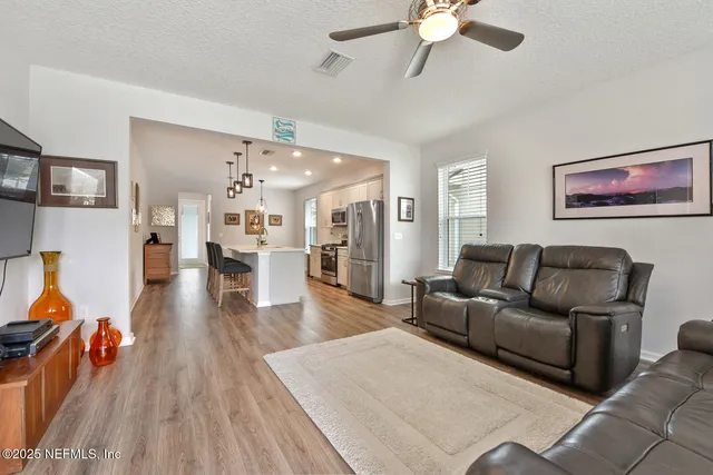 a living room with furniture and a view of kitchen