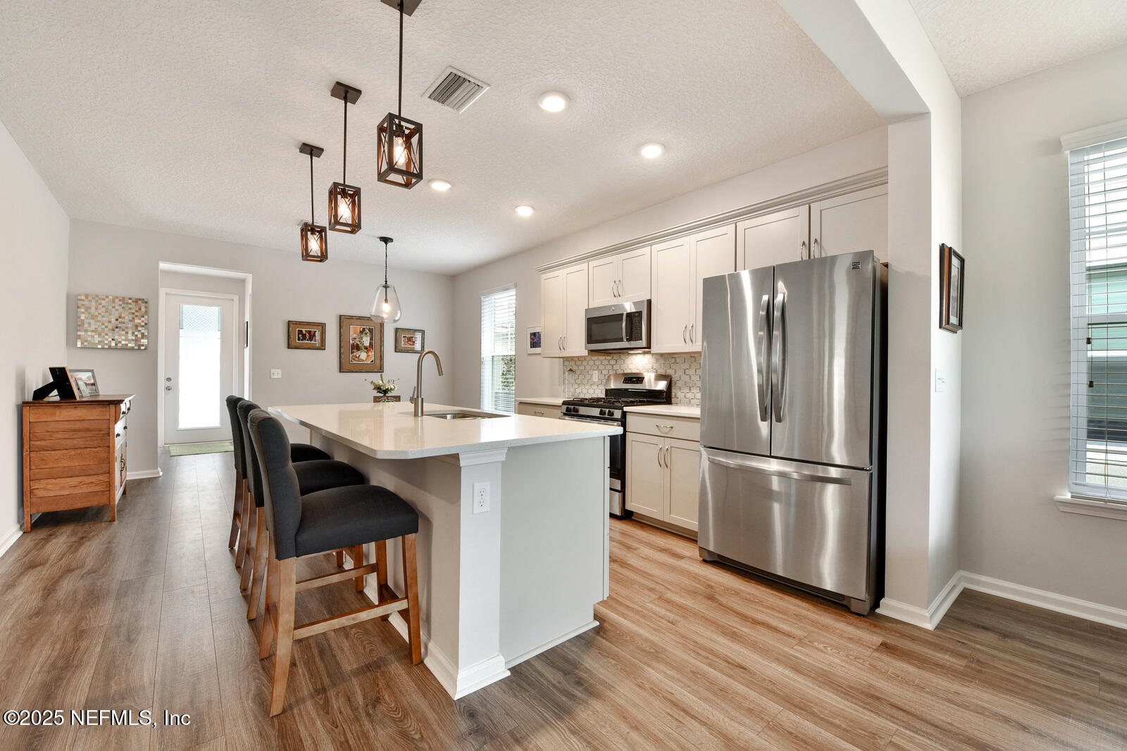 134 Jackrabbit Trail Ponte Vedra, FL 32081 - Photo 9 of 26 a kitchen with kitchen island wooden floors white appliances and cabinets
