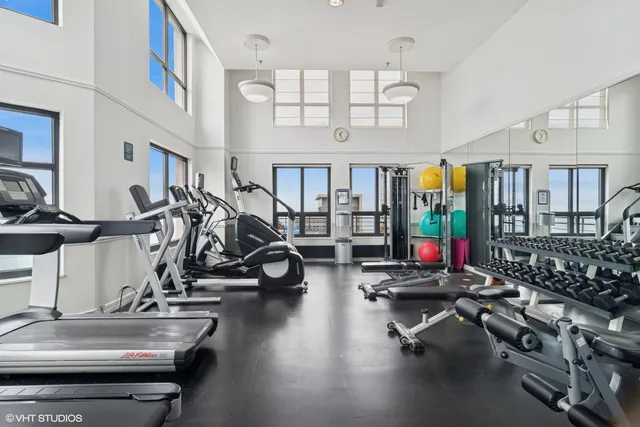 a view of a kitchen with kitchen island a sink wooden floor and a large window