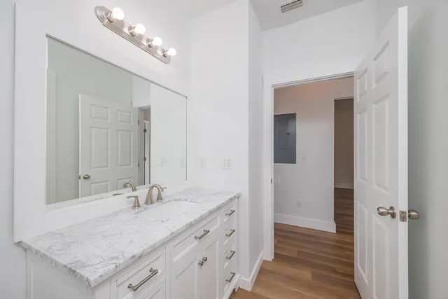 a bathroom with a granite countertop sink and a mirror