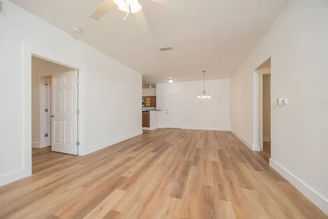 a view of empty room with wooden floor