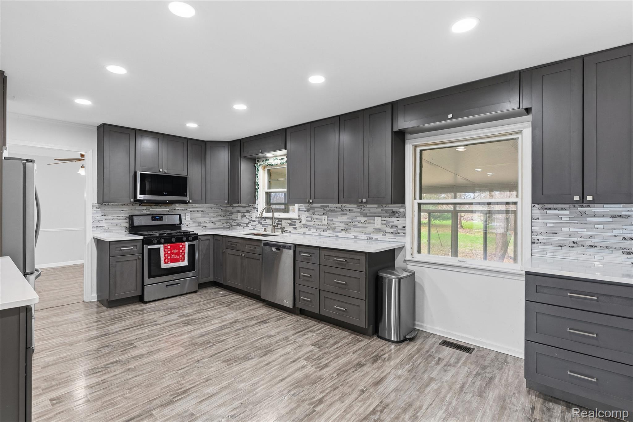 3432 South State Road Davison, MI 48423 - Photo 25 of 58 Kitchen with stainless steel appliances, healthy amount of natural light, backsplash, light wood-type flooring, and recessed lighting