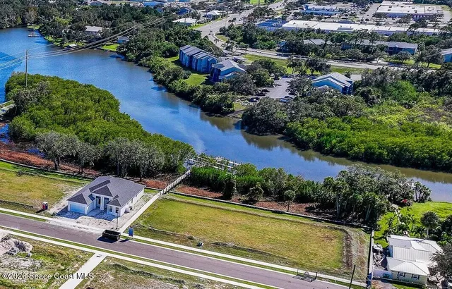 an aerial view of residential houses with outdoor space and lake view