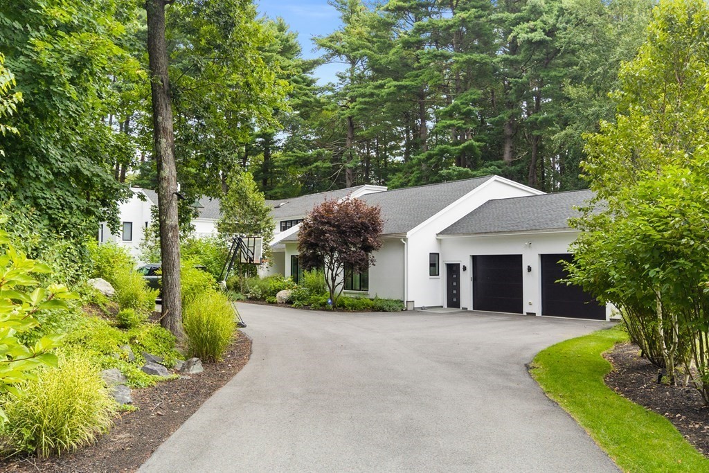 a view of a house with a yard and large tree