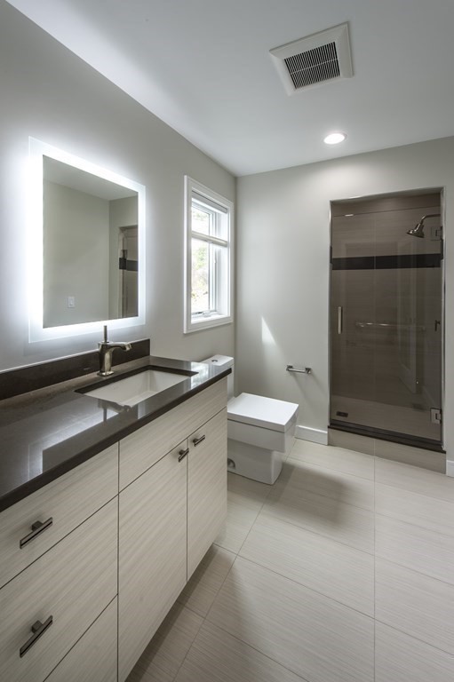 106 Windsor Road Needham, MA 02492 - Photo 25 of 37 a bathroom with a double vanity sink and a bathtub