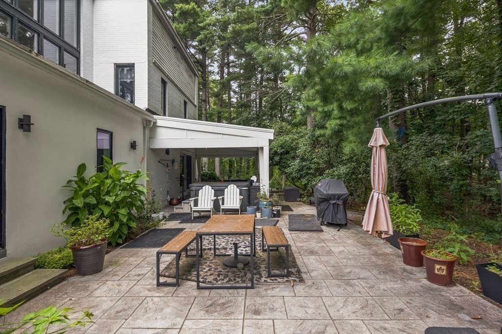 106 Windsor Road Needham, MA 02492 - Photo 29 of 37 a view of a patio with table and chairs potted plants and floor to ceiling window and potted plants
