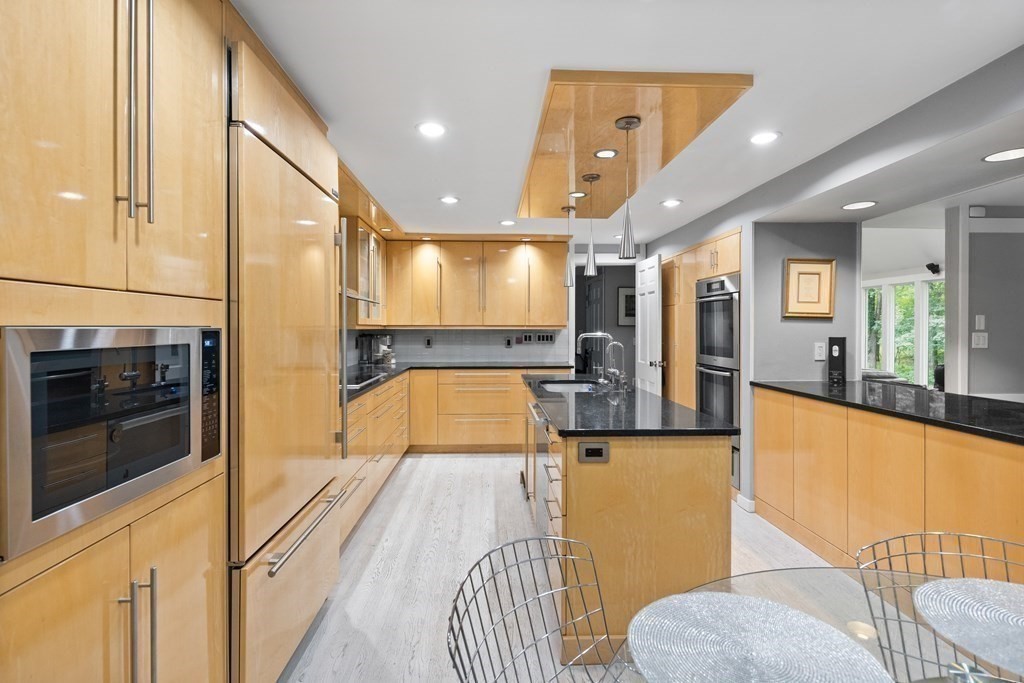 106 Windsor Road Needham, MA 02492 - Photo 9 of 37 a large kitchen with stainless steel appliances kitchen island granite countertop a refrigerator and a stove top oven