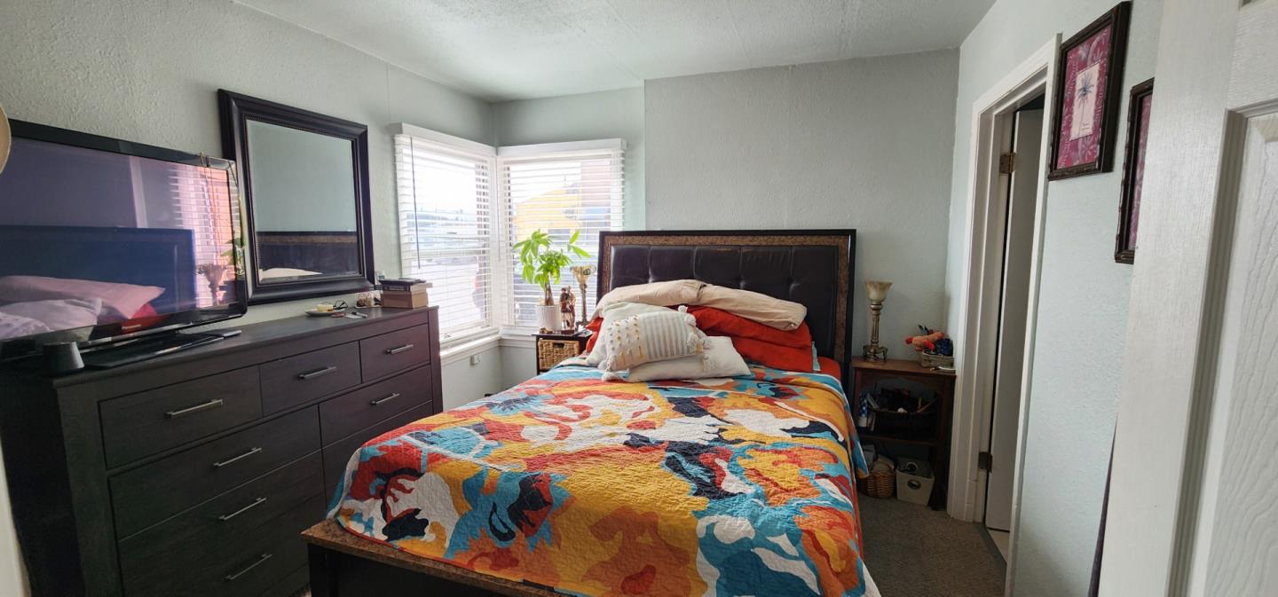 1591 Del Monte Boulevard Seaside, CA 93955 - Photo 6 of 20 a bedroom with a bed and wooden floor