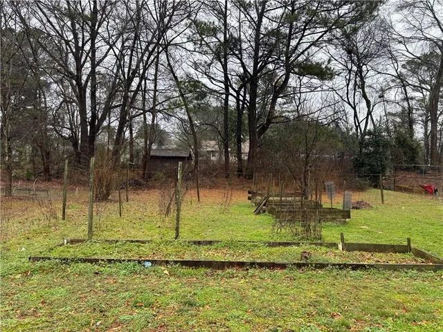 a view of an empty room with kitchen and a window