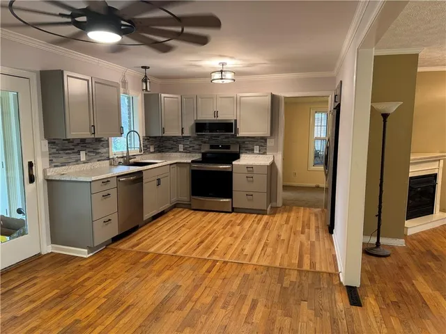 a kitchen with stainless steel appliances granite countertop a stove cabinets and wooden floor
