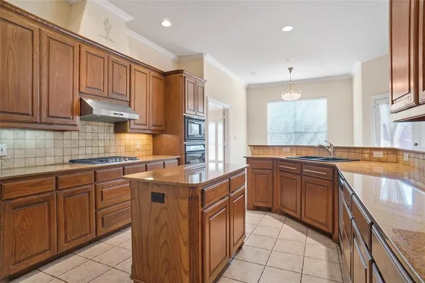 a kitchen with stainless steel appliances granite countertop wooden cabinets and sink