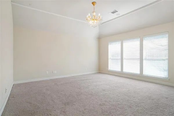 en empty room with windows and chandelier