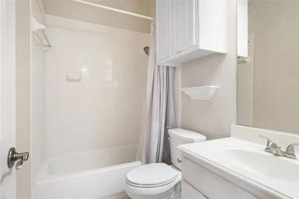 a white toilet sitting next to a bath tub
