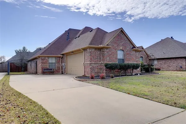 a front view of a house with a garden and yard