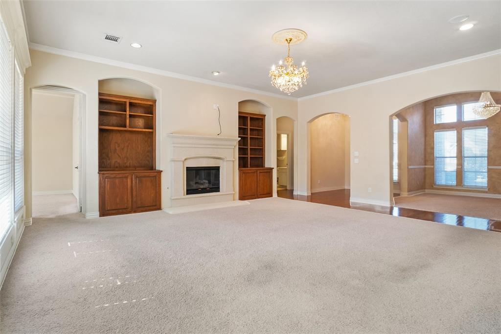 756 Trails End Circle Hurst, TX 76054 - Photo 7 of 26 an empty room with fireplace chandelier and windows
