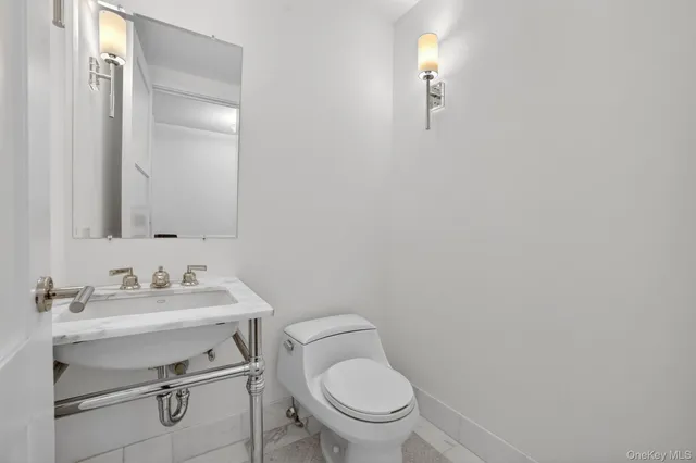a bathroom with a toilet sink vanity and mirror