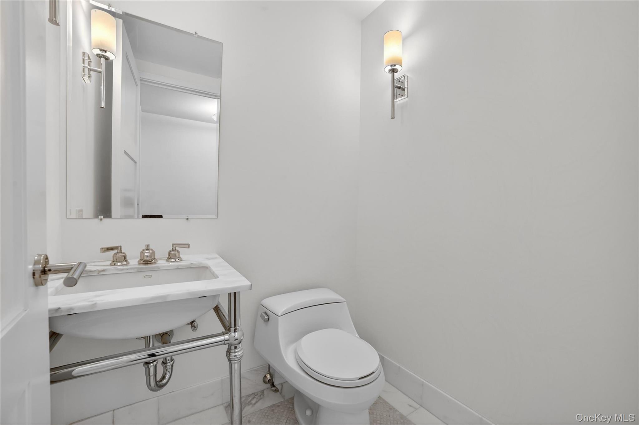 1 Renaissance Square, Unit 26F White Plains, NY 10601 - Photo 16 of 33 a bathroom with a toilet sink vanity and mirror