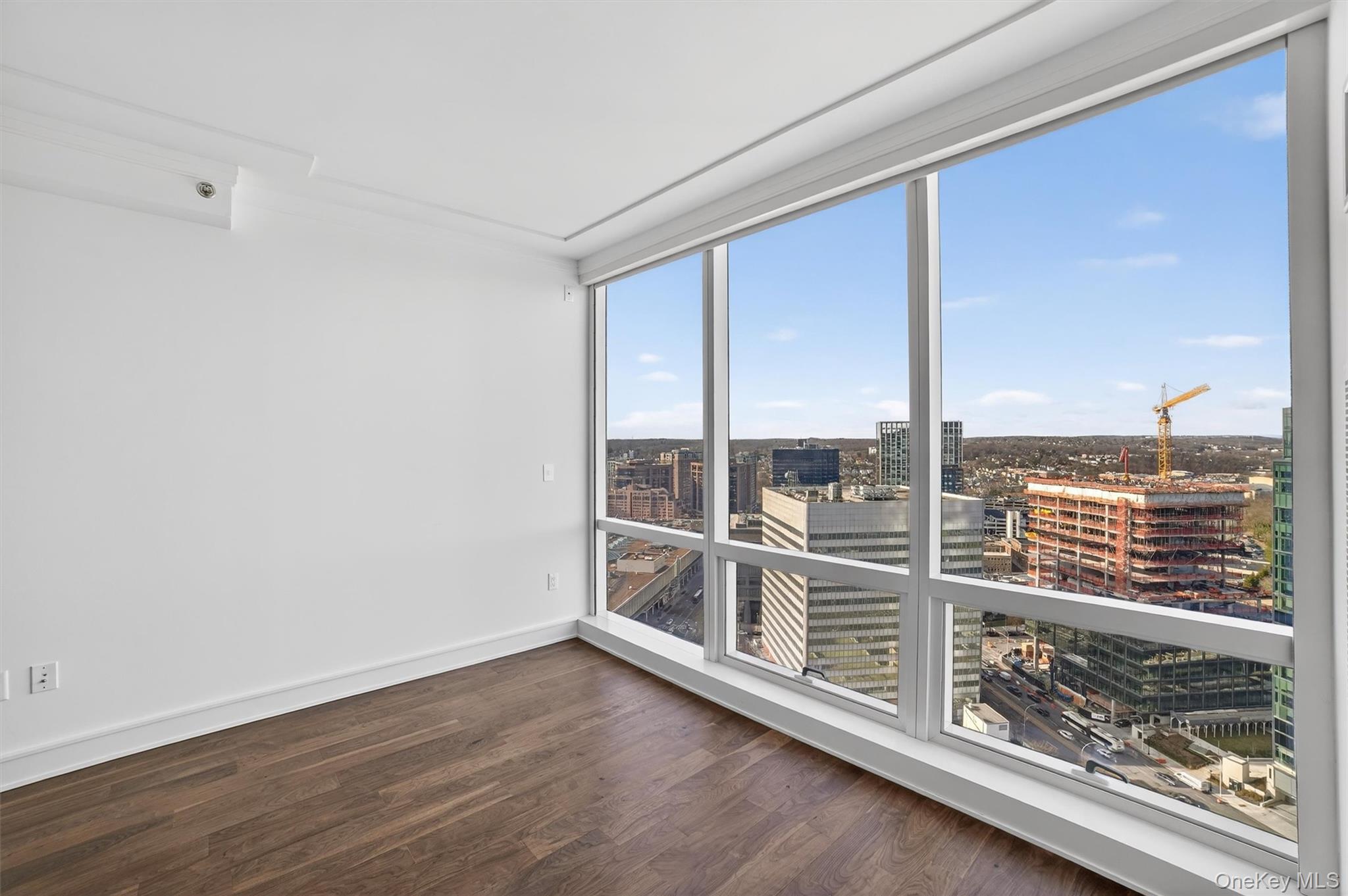 1 Renaissance Square, Unit 26F White Plains, NY 10601 - Photo 19 of 33 an empty room with wooden floor and windows