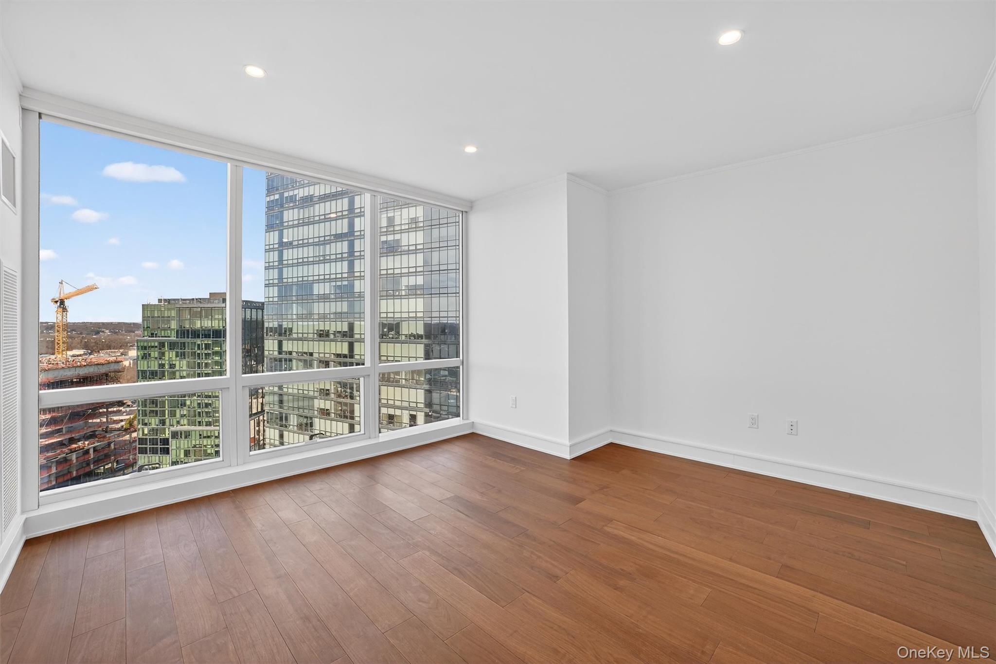 1 Renaissance Square, Unit 26F White Plains, NY 10601 - Photo 20 of 33 an empty room with wooden floor and windows