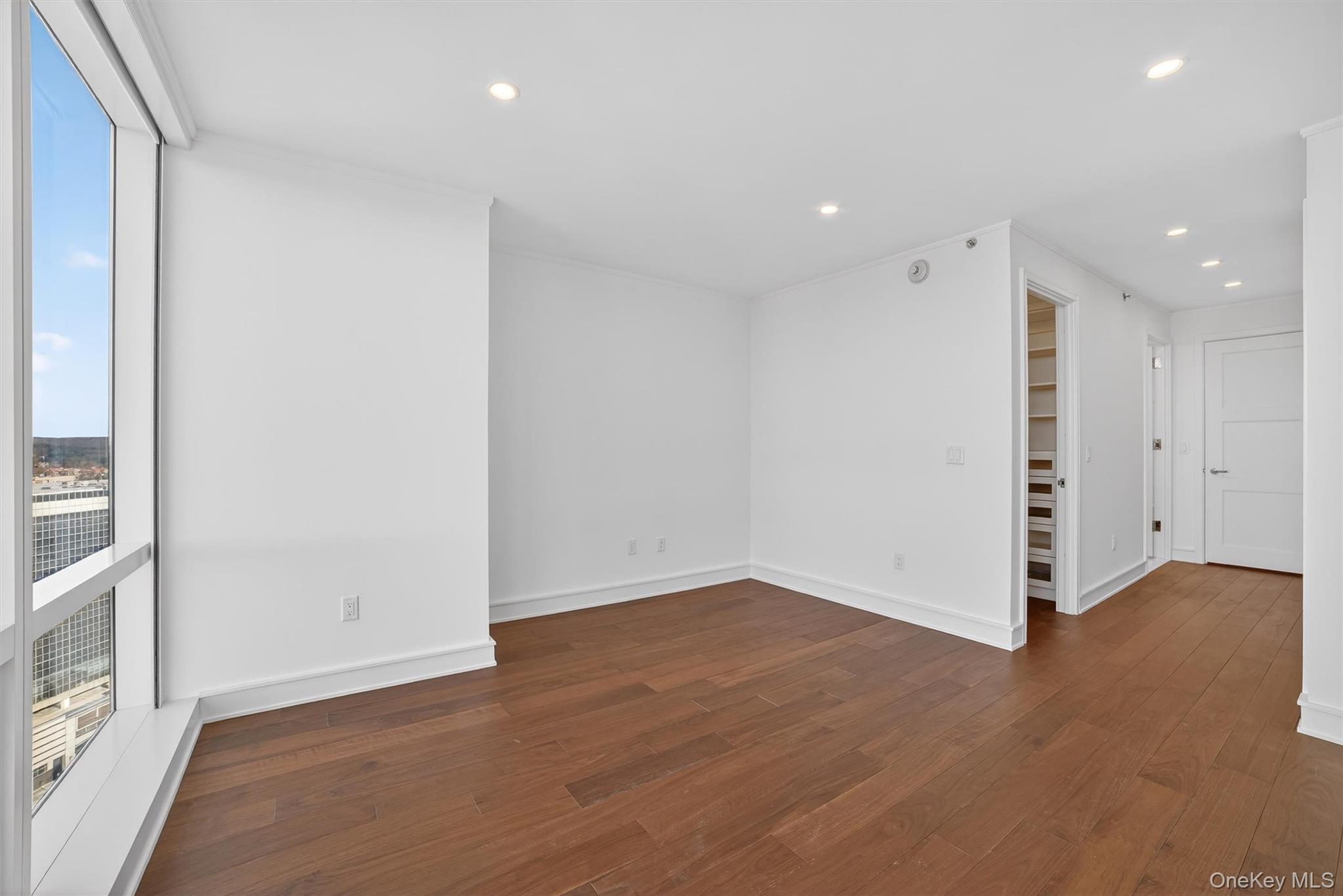 1 Renaissance Square, Unit 26F White Plains, NY 10601 - Photo 22 of 33 a view of an empty room with wooden floor and a window